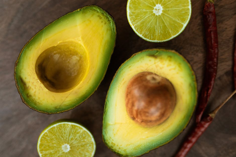 ripe avocado halves on natural linen background overhead view
