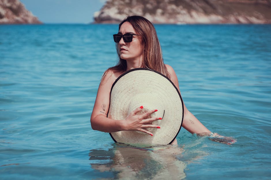 À 20 ans, pourquoi le soleil est déjà votre peau à protéger en priorité young woman with hat and sunglasses enjoying beach responsibly
