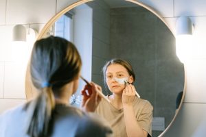 3 gestes express pour retrouver un teint éclatant avant une soirée woman radiant glowing skin evening beauty routine mirror