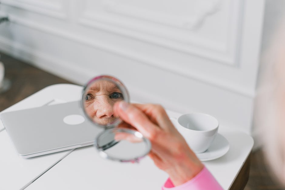 5 habitudes anti-âge simples et indolores pour ralentir le vieillissement cutané woman facial yoga exercises looking in mirror