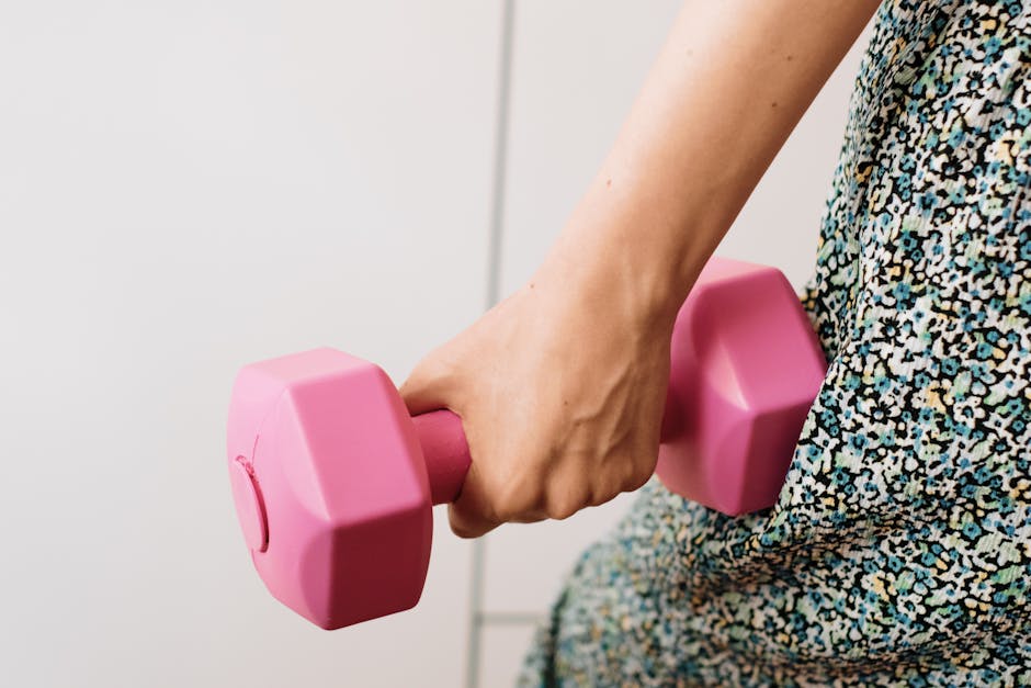 woman toned arms fitness home workout dumbbells natural light