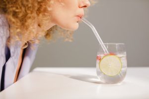 Déshydratation : 5 conséquences méconnues sur votre peau et votre santé woman drinking water glowing skin healthy lifestyle natural light landscape