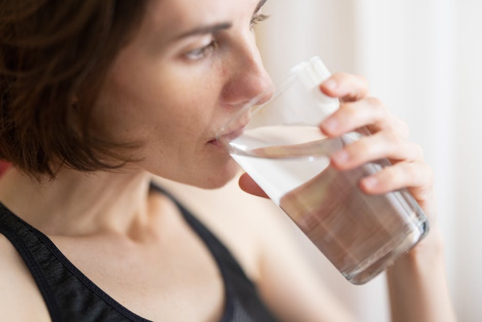 Déshydratation : 5 conséquences méconnues sur votre peau et votre santé woman drinking glass of water natural light skin glow