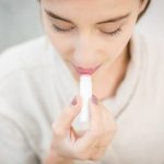 woman applying lip balm winter close up natural beauty