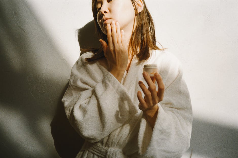 Pollution et peau : comment adapter sa routine beauté pour protéger son épiderme woman applying skincare cream in urban environment morning routine