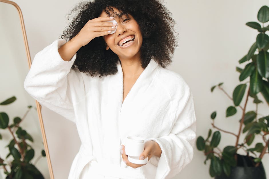Comment choisir son démaquillant selon son type de peau woman removing makeup gently with cotton pad in bathroom mirror