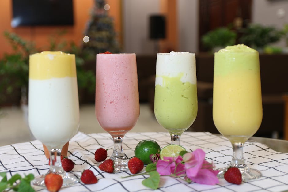 Smoothies bronzants : 5 recettes aux actifs naturels pour préparer sa peau au soleil fresh colorful smoothies with fruits and vegetables on wooden table summer