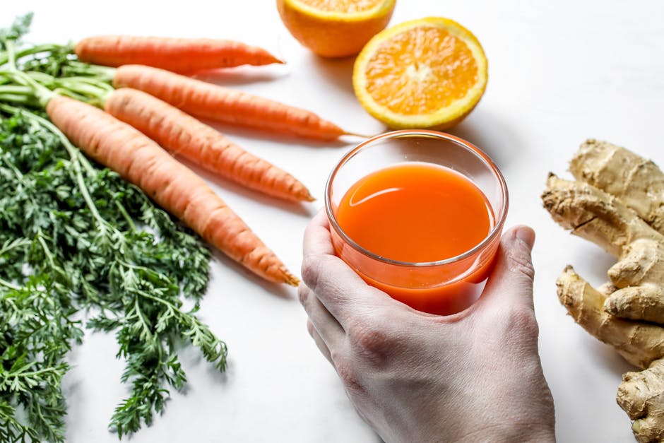 Smoothies bronzants : 5 recettes aux actifs naturels pour préparer sa peau au soleil glass of orange carrot tomato smoothie with fresh ingredients white background