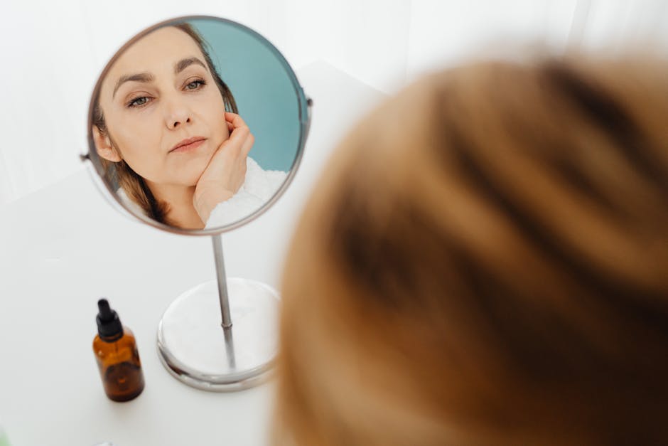 Grains de beauté : tout ce que vous devez savoir pour les surveiller person examining skin in mirror self examination