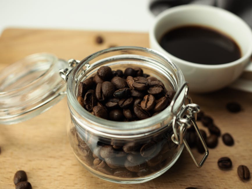 Gommage au café : bienfaits réels, limites et recette maison coffee scrub glass jar coffee beans wooden surface