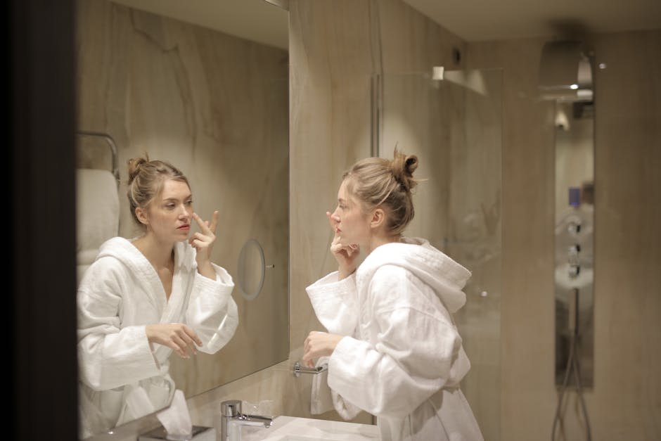 Peau hydratée en hiver : le guide complet pour affronter le froid sans tiraillements woman applying moisturizer cream on face in winter cozy bathroom