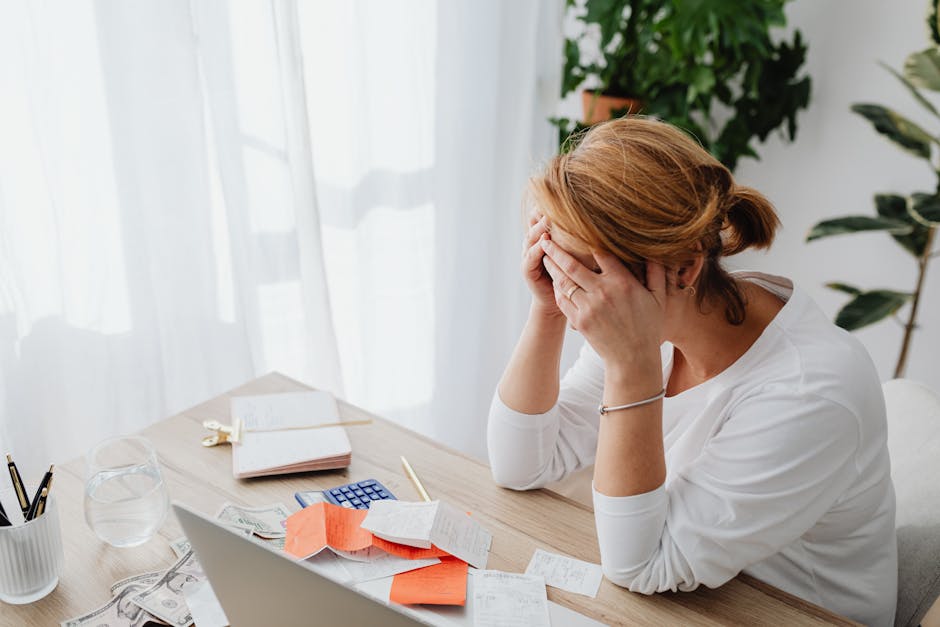Pourquoi votre visage se fatigue au fil de la journée (et comment y remédier) tired woman office desk city pollution background
