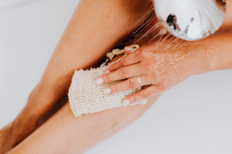 Comment prendre soin de son dos : gommage, hydratation et posture woman applying body scrub in bathroom shower skincare routine