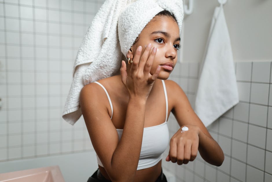 woman applying moisturizer on face in winter cozy bathroom