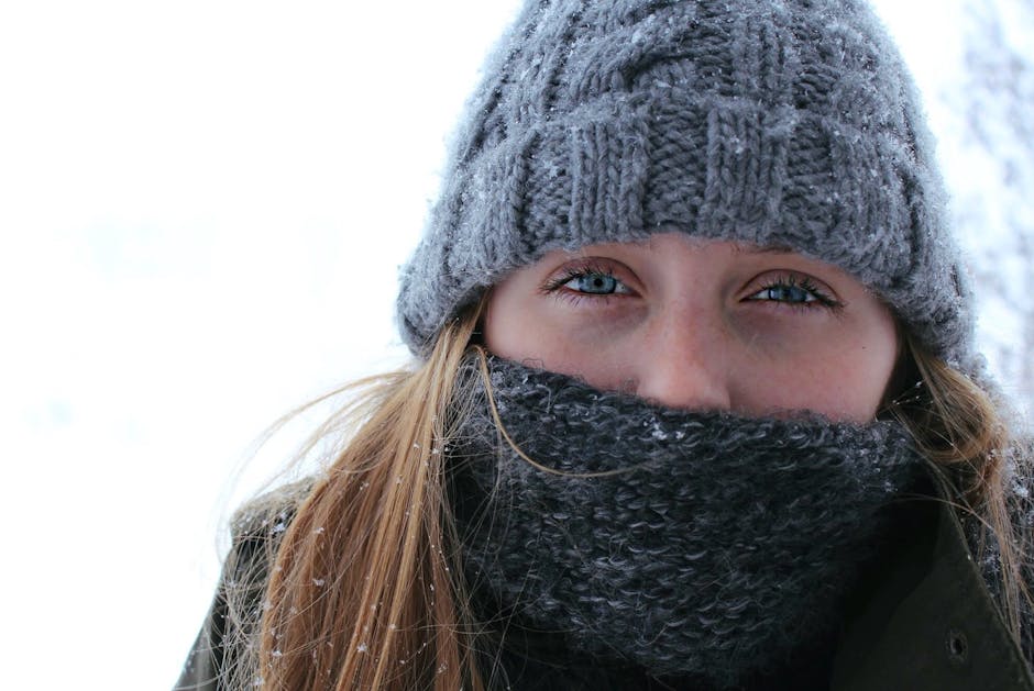 Rester au chaud en hiver : 8 réflexes naturels pour le corps et la peau woman bundled up in winter clothes scarf and hat outdoors cold weather