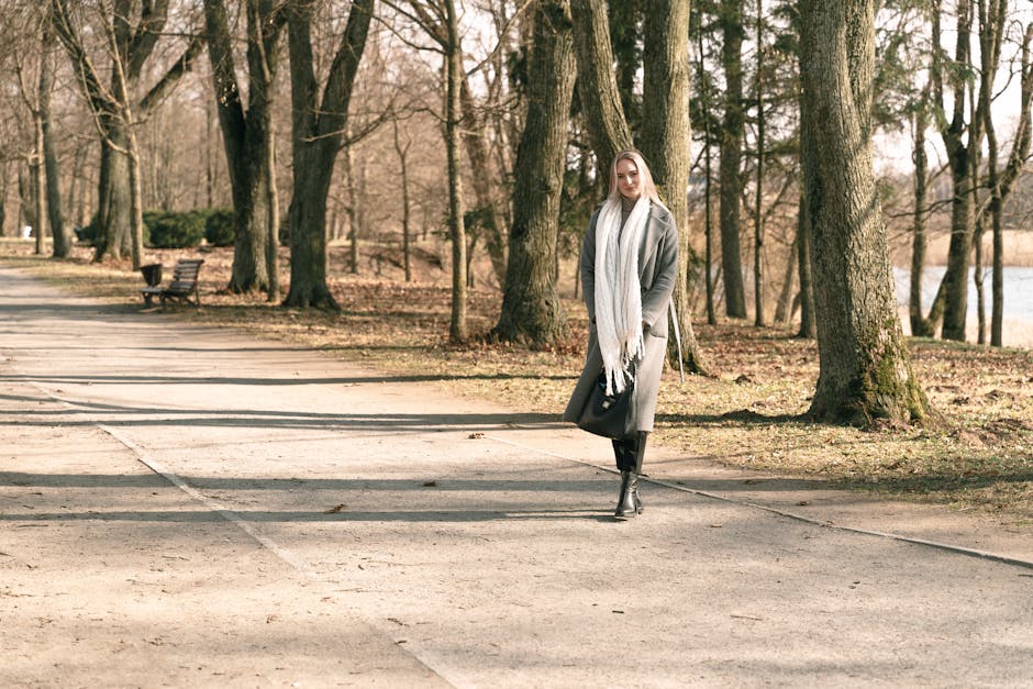 Rester au chaud en hiver : 8 réflexes naturels pour le corps et la peau woman walking briskly in winter park coat scarf energetic
