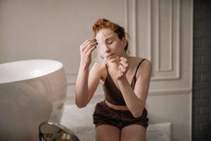 Comment préparer sa peau avant un masque visage : les 3 étapes clés woman applying face mask skincare routine relaxed bathroom