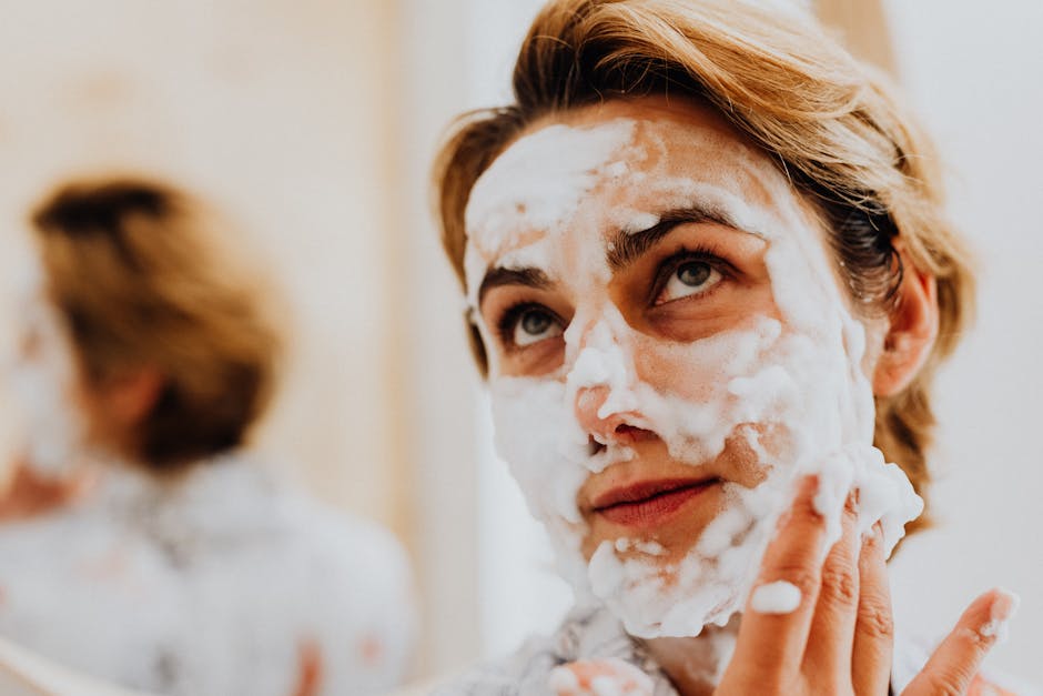 Comment préparer sa peau avant un masque visage : les 3 étapes clés woman washing face with foam cleanser morning skincare