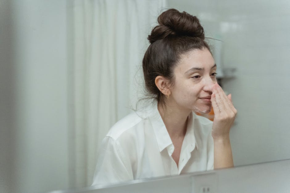 Comment booster l'efficacité de votre crème visage : les bonnes pratiques à adopter woman massaging moisturizer into face with circular motions