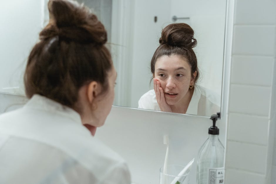 Auto-examen des grains de beauté : comment surveiller vos nævi à la maison person examining skin moles mirror bathroom