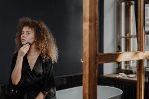 Démaquillage : quelle texture choisir selon son type de peau ? woman skincare routine evening makeup removal bathroom natural light landscape