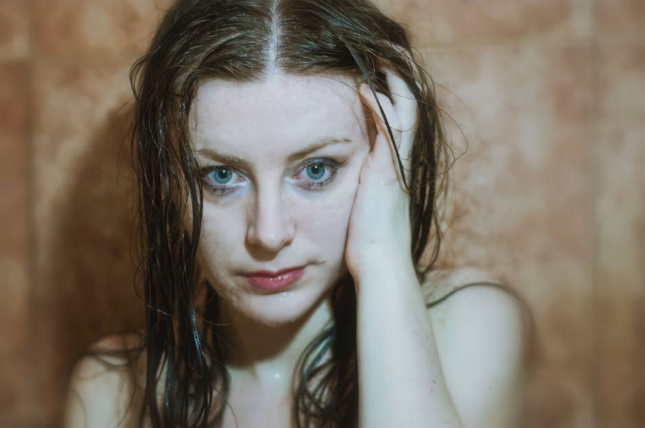 Peau Sensible et Douche : Comment Protéger Votre Épiderme Sans le Fragiliser sensitive skin woman shower water drops calm bathroom