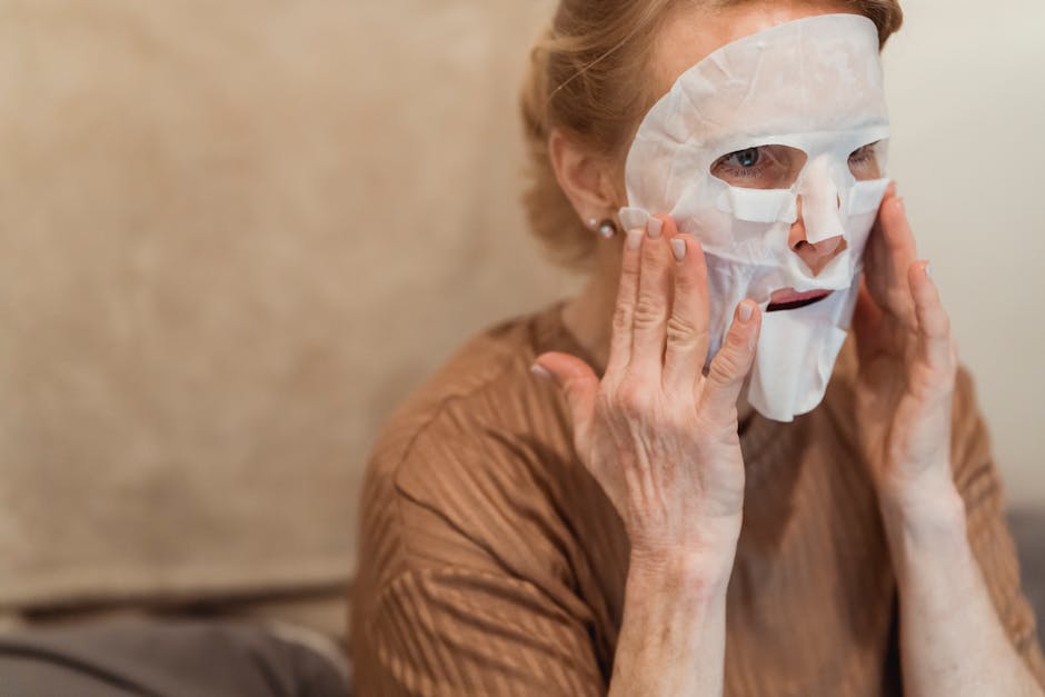 Masques anti-âge : bienfaits, actifs clés et recette maison pour une peau repulpée mature woman applying face mask skincare routine