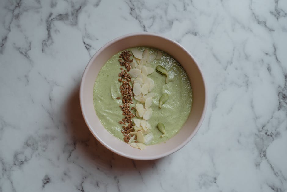Chlorophylle et peau : bienfaits, vertus anti-âge et sources alimentaires green smoothie bowl spirulina spinach healthy breakfast top view