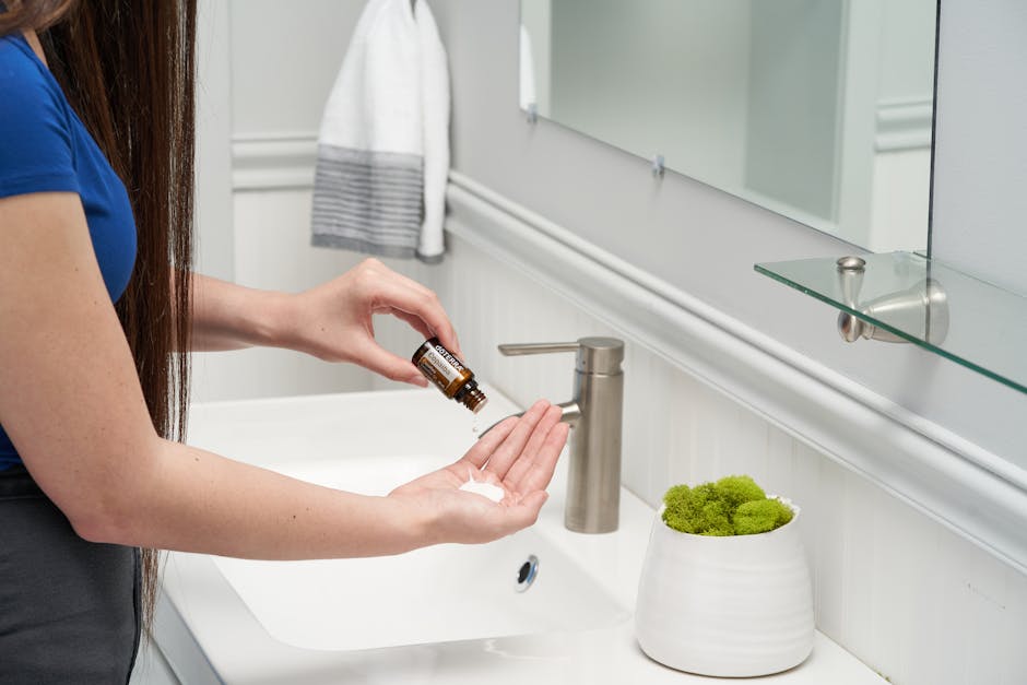 Huile de douche : pourquoi elle transforme votre rituel nettoyant woman applying shower oil in bathroom warm light