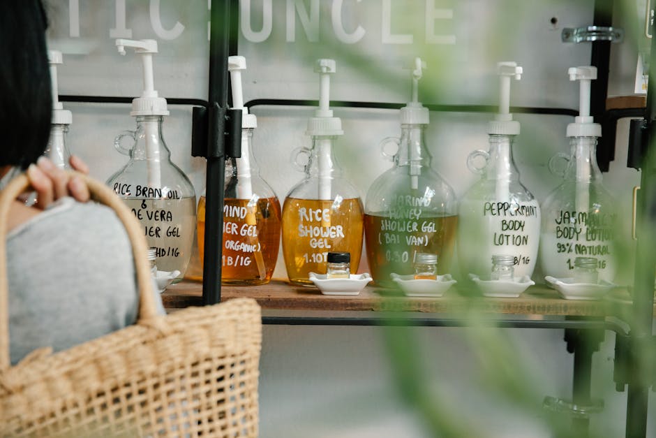 Huile de douche : pourquoi elle transforme votre rituel nettoyant comparison shower gel and shower oil bottles flat lay