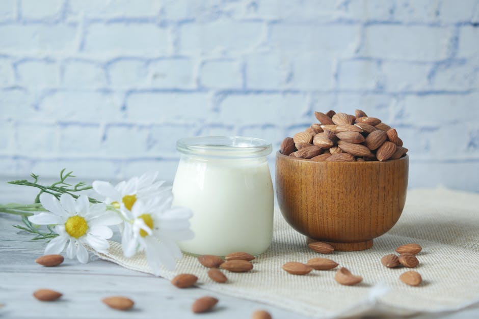 Huile d'amande douce : le soin naturel idéal pour les peaux irritées et sèches sweet almond oil glass bottle almonds wooden table