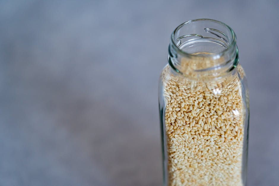 Huile de ricin : bienfaits pour la peau, les cheveux et les ongles castor oil glass bottle seeds wooden surface natural