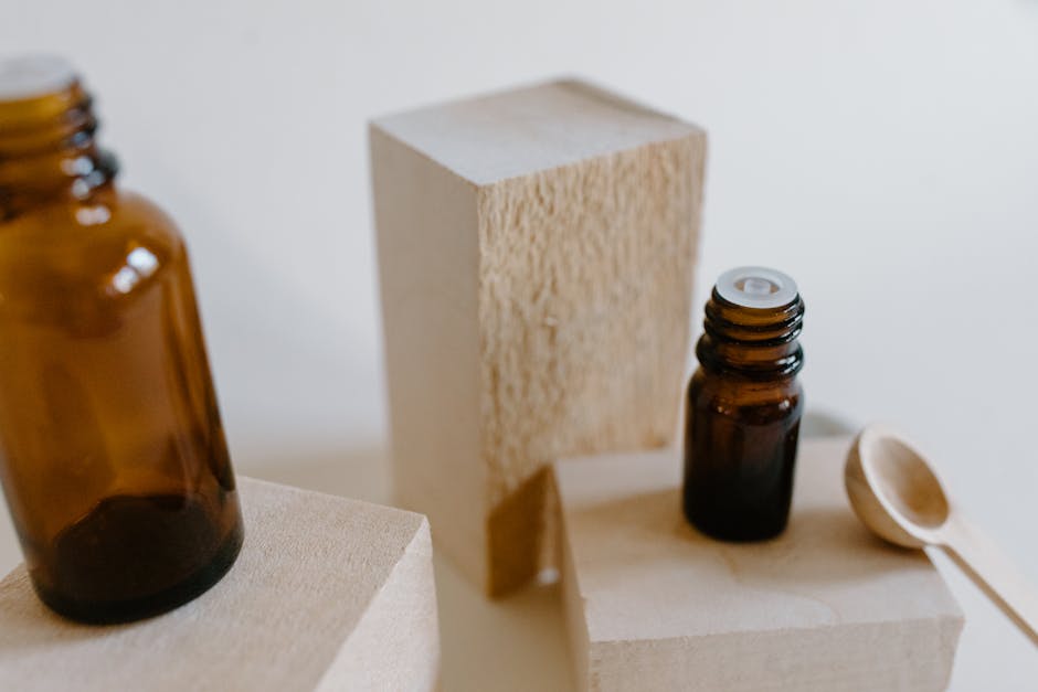 Huiles essentielles et éclat du teint : lesquelles choisir et comment les utiliser ? essential oils small bottles dropper natural background botanicals