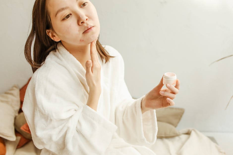 Huiles essentielles et éclat du teint : lesquelles choisir et comment les utiliser ? woman applying facial oil skin care routine morning glow