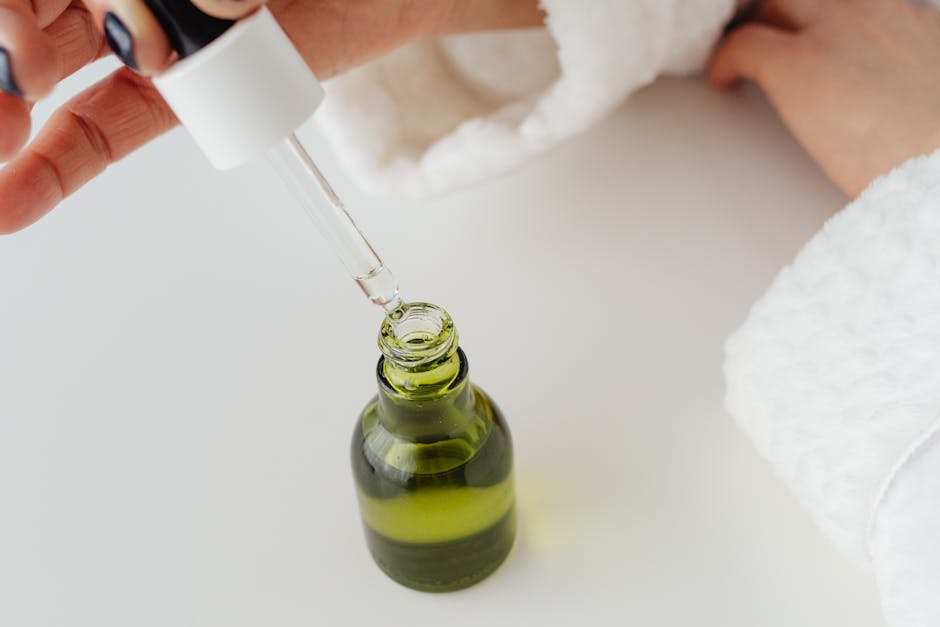 Huile visage : guide complet pour choisir, appliquer et sublimer votre peau woman applying facial oil dropper bottle skincare routine