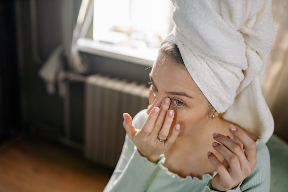Caféine et contour des yeux : l'actif drainant qui aide à réduire poches et cernes woman applying eye cream fingertip morning skincare routine
