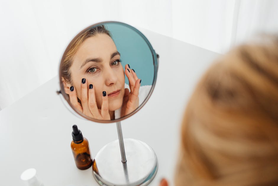 Peau mixte : comprendre, identifier et prendre soin de ce type de peau woman examining her skin in mirror close up natural light