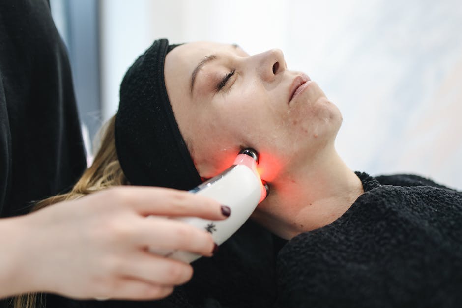 Photothérapie anti-âge : comment la lumière LED aide à atténuer les rides woman receiving LED light therapy facial treatment in beauty clinic