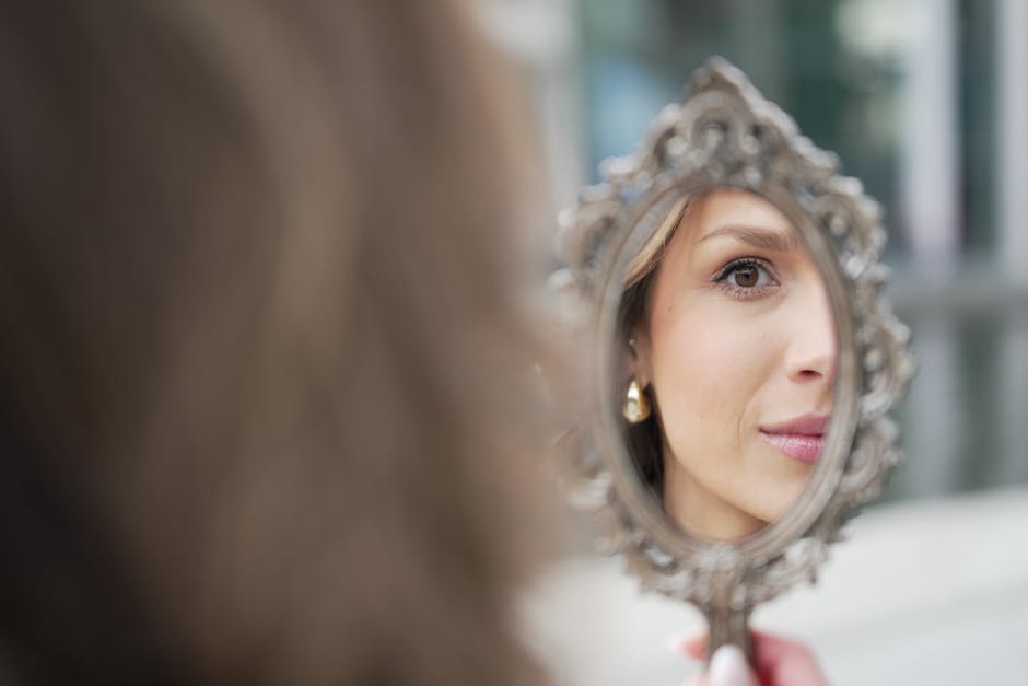 Ride du lion : comprendre ses causes et les soins pour l'atténuer woman looking in mirror examining forehead wrinkles close-up natural light