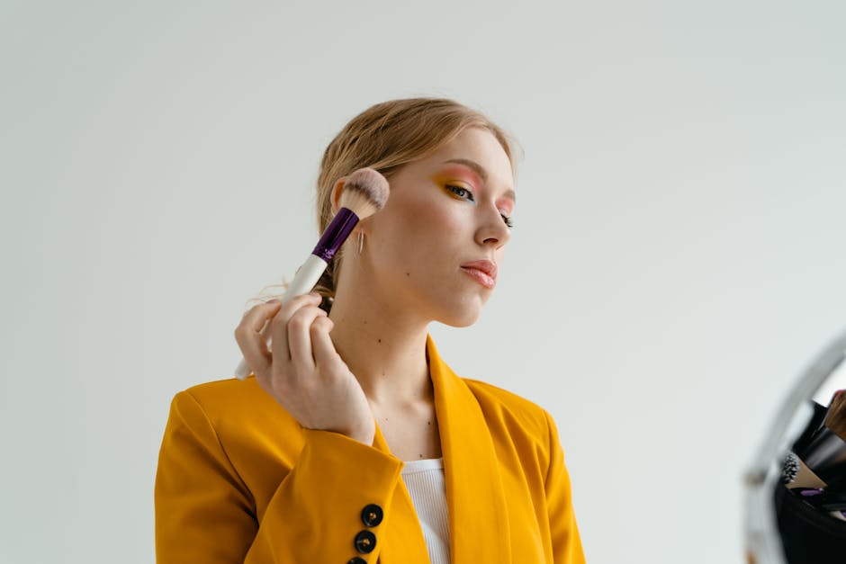 Le teint dewy : comment obtenir un éclat frais et naturel à tout âge makeup brush applying foundation highlighter glowing luminous skin