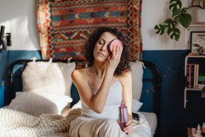 Gant démaquillant : avantages, inconvénients et conseils pour bien l'utiliser woman using microfiber makeup remover glove bathroom skincare routine landscape