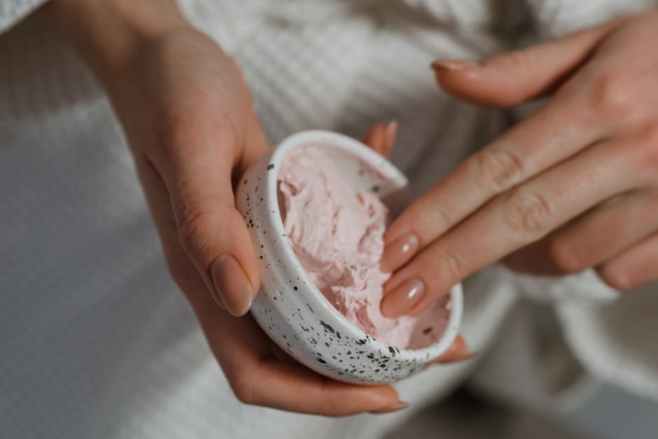 Obtenir un teint lumineux naturellement : le rituel beauté étape par étape woman blending tinted moisturizer fingertips natural skin glow