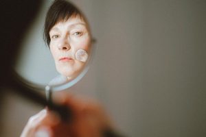 Peau à 65 ans : comprendre les changements et adapter sa routine beauté elegant mature woman skincare routine natural light portrait landscape
