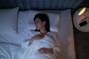Sommeil réparateur : les habitudes qui changent vraiment la qualité de vos nuits peaceful woman sleeping deeply cozy bedroom night recovery