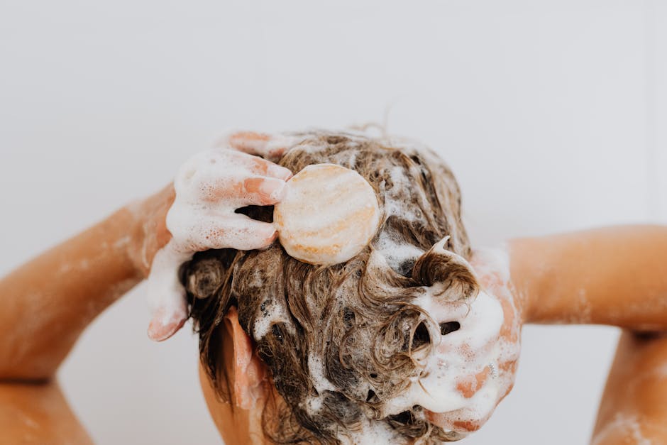 Cosmétiques solides : avantages, limites et conseils pour les adopter au quotidien woman washing hair with solid shampoo bar in shower