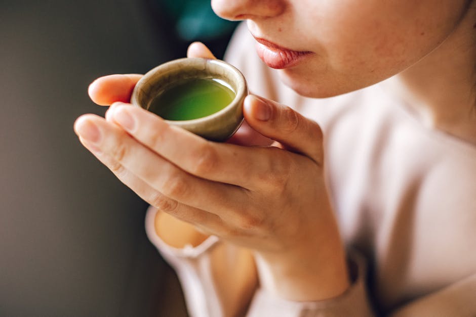 Flavonoïdes : bienfaits pour la peau, sources alimentaires et conseils pratiques woman with glowing healthy skin holding a green tea cup natural light