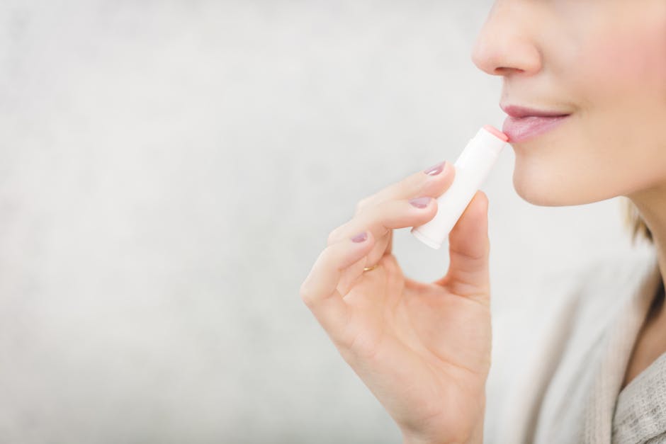 woman applying natural lip balm winter cold weather close up lips