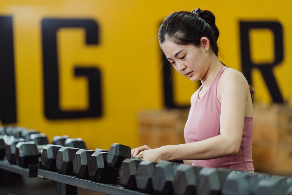 woman doing strength training with dumbbells in a gym
