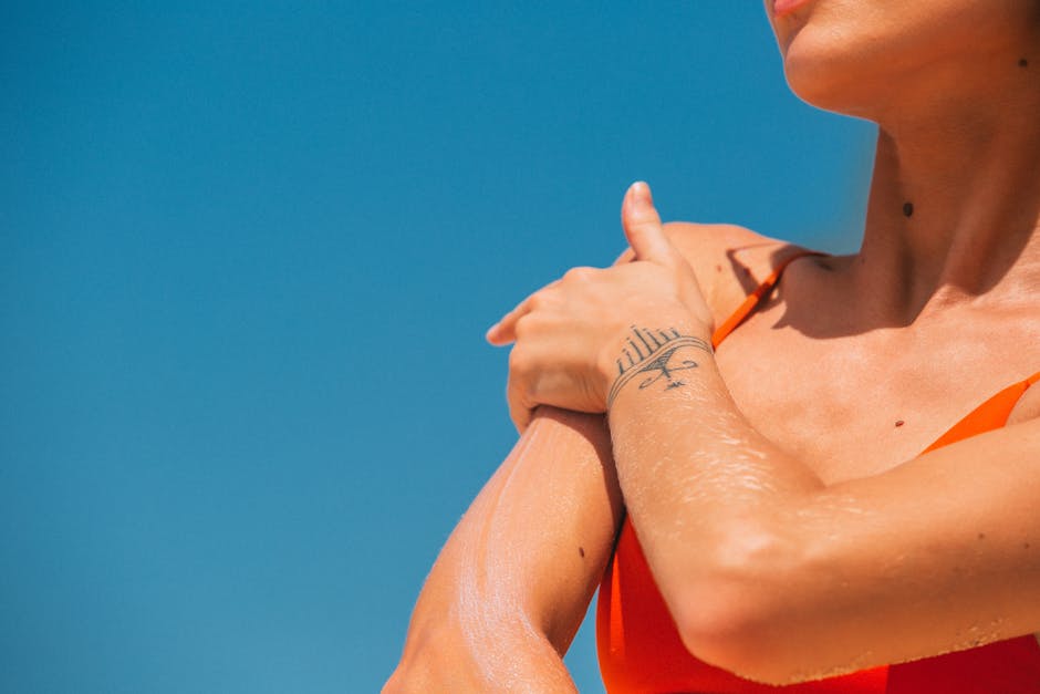 Protection solaire au printemps : pourquoi c'est la saison la plus risquée pour votre peau closeup of woman applying sunscreen on arm outdoor spring green background