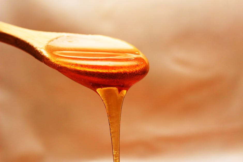 Les trésors de la ruche pour la peau : miel, gelée royale, propolis et pollen honey dripping wooden surface flowers background